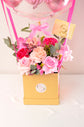 Pink flowers with balloons in box