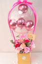Pink flowers with balloons in box