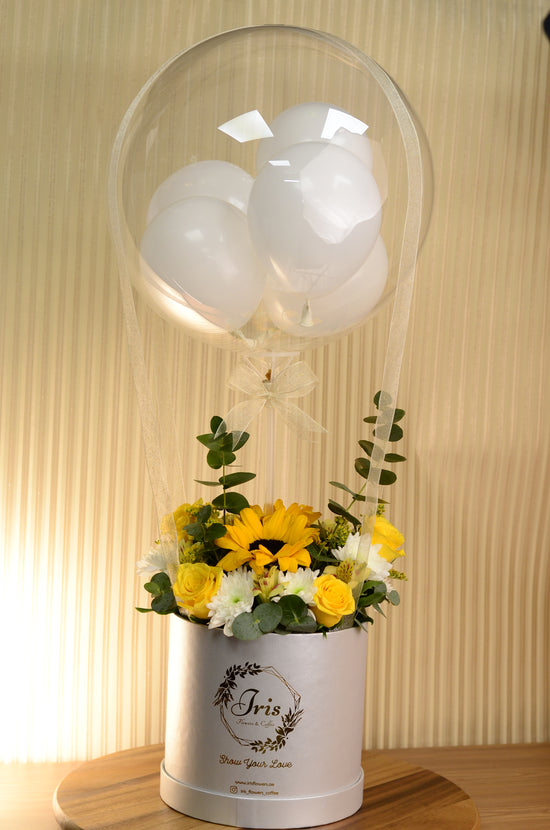 Yellow flowers with balloon in box